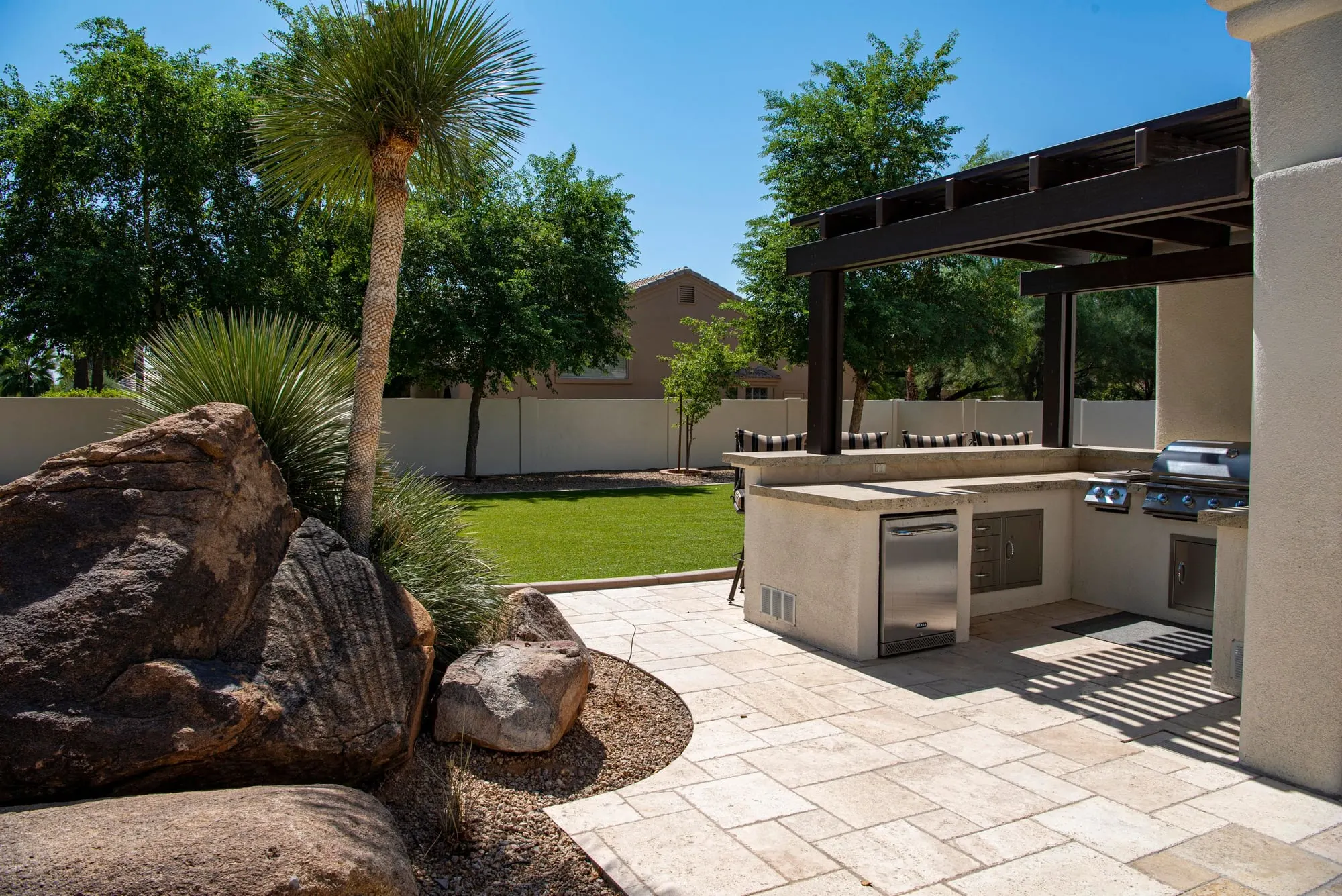 Outdoor kitchen on a travertine-style patio